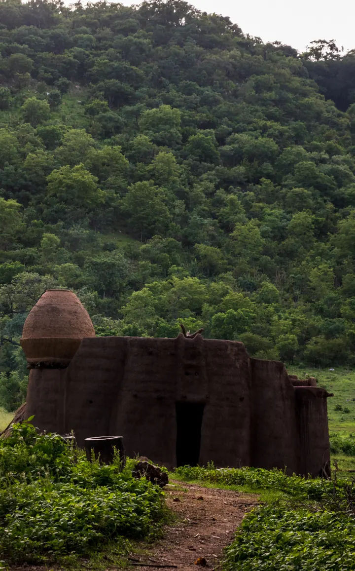 Une tata somba, maison-forteresse en terre à tourelles, adossée aux collines vertes du pays tamberma